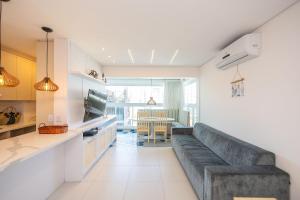 a living room with a couch and a kitchen at Venice Home Club - Balneário Piçarras in Itajubá