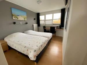 a small bedroom with a bed and a desk at Duinoord Domburg in Domburg