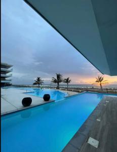 a swimming pool with a view of the ocean at Kololi Sands in Serekunda