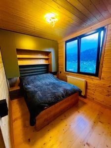 a bedroom with a bed and a large window at Bakhmaro Mountains in Chʼkhakoura