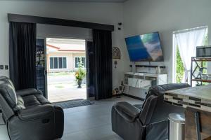 a living room with two chairs and a table at JJ Lux Residential in Jacó