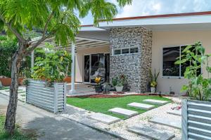 a house with a palm tree in the yard at JJ Lux Residential in Jacó