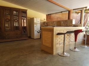 a kitchen with a counter and two bar stools at O Caminho das Cachoeiras in Cavalcante