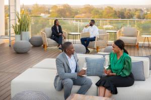 a group of people sitting on a couch on a balcony at InterContinental Lusaka by IHG in Lusaka +84 photos