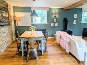 a dining room with a table and a couch at South Cotswolds cottage in Great Somerford