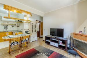 eine große Küche mit einem Tisch und einem TV in der Unterkunft Apto 300m do lago negro em Gramado/RS RLN0104 in Gramado