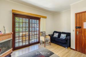 ein Wohnzimmer mit Sofa und Fernseher in der Unterkunft Apto 300m do lago negro em Gramado/RS RLN0104 in Gramado