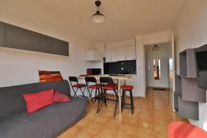 een woonkamer met een bank en een tafel met stoelen bij Ciel et mer in Sausset-les-Pins