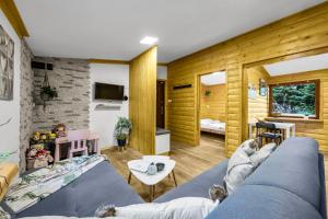 a living room with a blue couch and wooden walls at Dom na Cuplu - Zalew Zegrzynski - by Rentujemy in Cupel