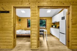 a kitchen and dining room in a wooden house at Dom na Cuplu - Zalew Zegrzynski - by Rentujemy in Cupel