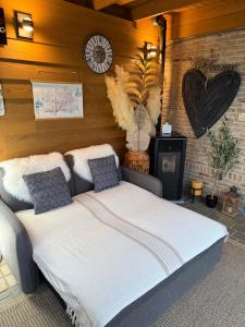 ein Schlafzimmer mit einem großen Bett und einer Uhr an der Wand in der Unterkunft Glamping & wellness Moonlight in Brakel + 45 Fotos