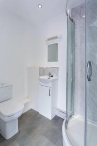 ein weißes Badezimmer mit Toilette und Dusche in der Unterkunft Central Derby Ensuite Rooms for Contractor Stays in Derby