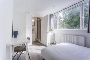 ein Schlafzimmer mit Bett, Schreibtisch und Fenster in der Unterkunft Central Derby Ensuite Rooms for Contractor Stays in Derby