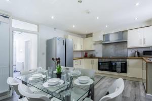 eine Küche mit einem Glastisch und weißen Stühlen in der Unterkunft Central Derby Ensuite Rooms for Contractor Stays in Derby + 17 Fotos