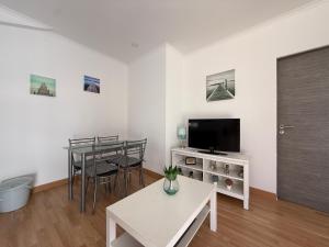 un soggiorno con un tavolo e una tv di Refúgio Dourado a Lourinhã