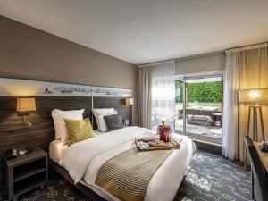 a hotel room with a large bed and a balcony at Mercure Annecy Sud in Annecy