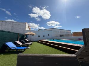 una piscina con lettini e un ombrellone di Refúgio Dourado a Lourinhã