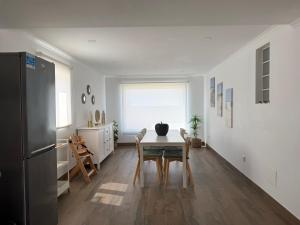 una cucina e una sala da pranzo con tavolo e sedie di Refúgio Dourado a Lourinhã