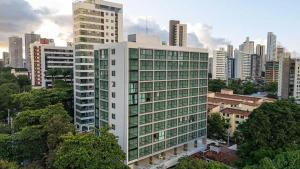a tall white building in front of a city at Casa Forte Prince - Flat a 500m do Shopping Plaza by Yolo in Recife