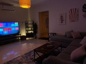 Una sala de estar con un sofá y un televisor de pantalla plana. en Elegant apartment close to Al Sariyah roundabout, en Yeda 1 foto más