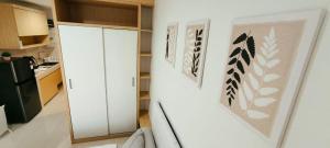 eine Küche mit einem weißen Kühlschrank mit Bildern an der Wand in der Unterkunft Springwood Bright Escape Studio in Warungmangga