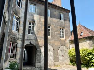 un vecchio edificio in pietra con un arco davanti di Le Granvelle a Besançon