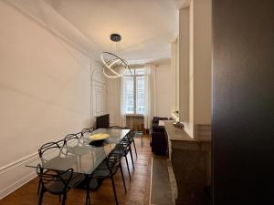 una sala da pranzo con tavolo e sedie in vetro di Le Granvelle a Besançon