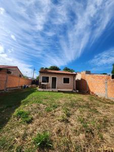 a small house in a yard next to a brick wall at Casa Nova aeroporto in Luque