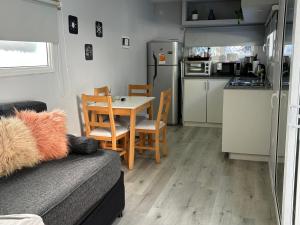 a living room with a table and a kitchen at El Rincón, en el bosque de Bariloche in San Carlos de Bariloche