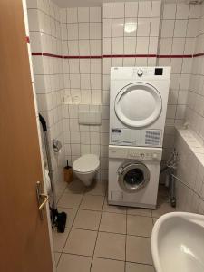ein kleines Bad mit einer Waschmaschine und einem WC in der Unterkunft 3 Schlafzimmer, Wohnzimmer, Küche, Bad, Terrasse, Parkplatz in Wörrstadt