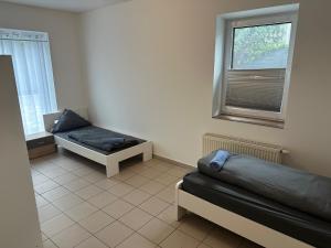 ein Zimmer mit zwei Betten und einem Fenster in der Unterkunft 3 Schlafzimmer, Wohnzimmer, Küche, Bad, Terrasse, Parkplatz in Wörrstadt