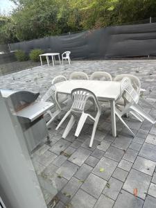 einen weißen Tisch und Stühle auf einer Terrasse in der Unterkunft 3 Schlafzimmer, Wohnzimmer, Küche, Bad, Terrasse, Parkplatz in Wörrstadt
