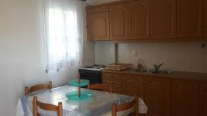 a kitchen with a table with chairs and a sink at Hibiscus Studios in Parikia