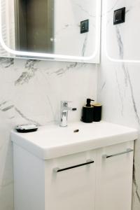 a white bathroom with a sink and a mirror at Nuance Residences - Momento in Volos +20 photos