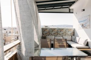 a balcony with a table and chairs and a couch at Nuance Residences - Momento in Volos