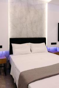 a bedroom with a large bed with white sheets at Nuance Residences - Momento in Volos