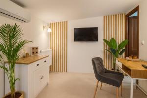 a living room with a dining table and a tv on the wall at Pensiune Heavens in Brăila