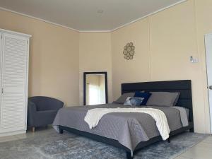 a bedroom with a bed and a mirror and a chair at Hibiscus Apartment in Corinthe