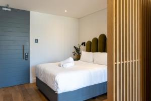 a bedroom with a large bed and a blue door at The Barracks City Pad in Cape Town +19 photos