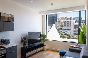 a living room with a couch and a large window at The Barracks City Pad in Cape Town