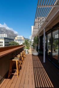 a bar with wooden tables and benches on a building at The Barracks City Pad in Cape Town