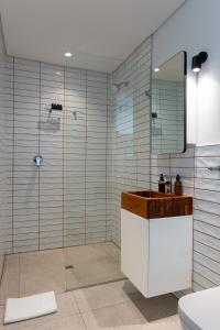 a bathroom with a shower and a sink and a mirror at The Barracks City Pad in Cape Town