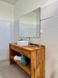 a bathroom with a sink and a mirror at Villa TULIA in Sainte-Luce