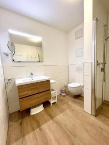 une salle de bain avec un lavabo et des toilettes dans l'établissement Haus Ostseewelle Wohnung Nr. 2, à Kühlungsborn 9 autres photos