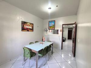 a dining room with a table and green chairs at Casa cop 30 in Belém