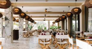 a restaurant with white chairs and tables and windows at Villa Verde · Pool · Guesthouse · Ping Pong in Jan Thiel