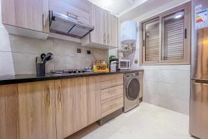een keuken met houten kasten en een wasmachine bij 2 bedrooms abouab gueliz in Marrakesh