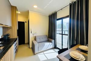 a living room with a couch and a table at Loft 108 - Conforto e praticidade no Santa Mônica. in Uberlândia