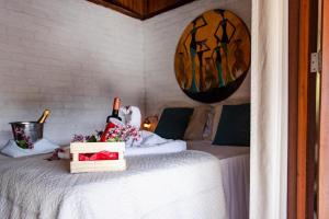 a bedroom with a bed with a bottle of wine on it at Pousada Maxitalia in Jericoacoara