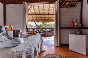 a bedroom with a bed and a large window at Pousada Maxitalia in Jericoacoara
